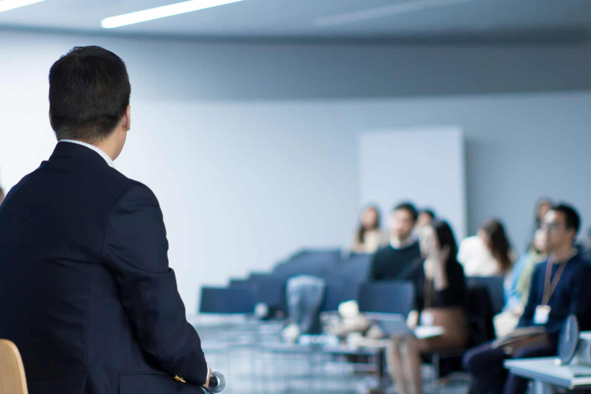 Person speaking in a lecture hall.